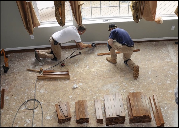 Hardwood flooring being cut and laid in a bright room